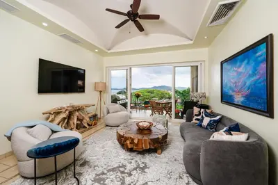 a living room with couches and a tv and a table at Oceanview in town Huge Pool Beach acss in Tamarindo