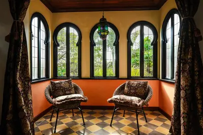 two chairs sitting in a room with windows at Exclusive private pool and steps to the beach in Tamarindo