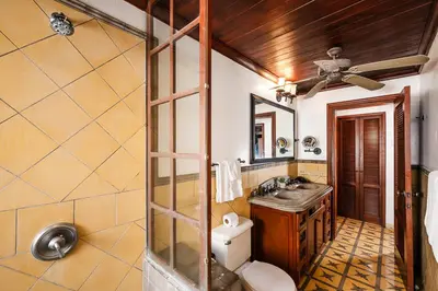 a bathroom with a toilet and a sink at Exclusive private pool and steps to the beach in Tamarindo
