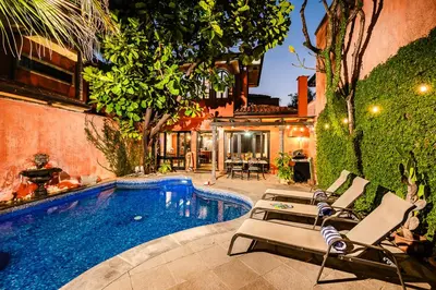 a swimming pool with lounge chairs next to a house at Exclusive private pool and steps to the beach in Tamarindo
