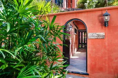 an entrance to a building with an archway and plants at Exclusive private pool and steps to the beach in Tamarindo