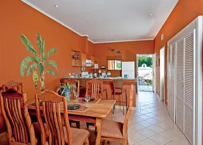 a kitchen and dining room with a wooden table and chairs at Beach Facing, large pool & guard in the town in Tamarindo