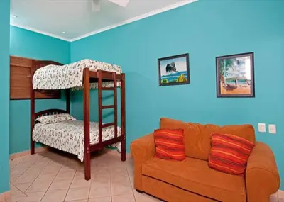a living room with a bunk bed and a couch at Beach Facing, large pool & guard in the town in Tamarindo