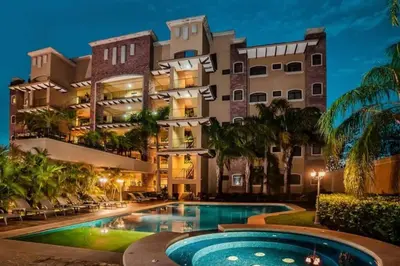 a hotel with a swimming pool in front of a building at Beachfront, Sunset, & Ocean Views with Elevator in Tamarindo