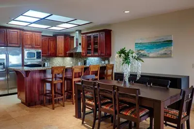 a kitchen with a table and chairs and a kitchen with a refrigerator at Beachfront, Sunset, & Ocean Views with Elevator in Tamarindo