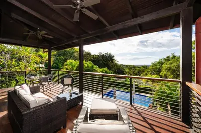 a deck with a view of the water and trees at Oceanview and Private Pool 8 mins to Downtown in Hernández