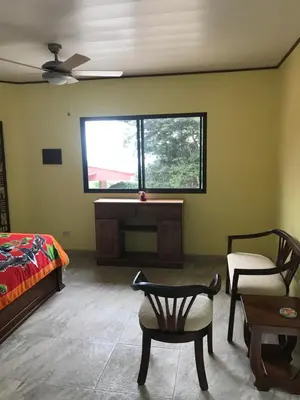 a bedroom with a bed and a table and a window at Villa Magallanes in San Ramón