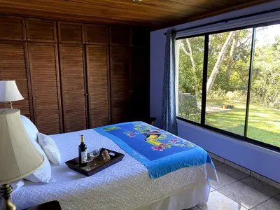 a bedroom with a bed and a large window at Villa Magallanes in San Ramón