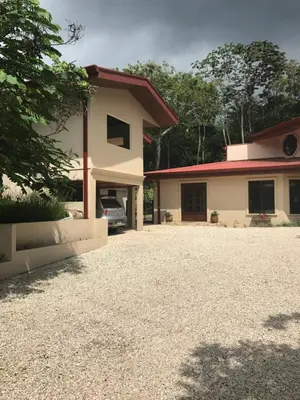 a house with a car parked in the driveway at Villa Magallanes in San Ramón