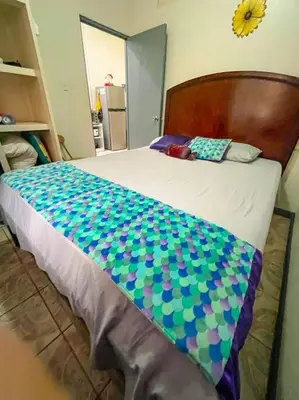a bed with a blue and green comforter on it at Escape to Pier Sands Casita#2- Close to the Beach. in Puntarenas