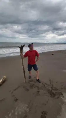 a man standing on the beach with a stick at Escape to Pier Sands Casita#2- Close to the Beach. in Puntarenas