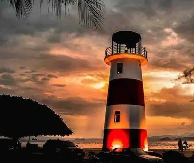 a red white and black lighthouse on the beach at Escape to Pier Sands Casita#2- Close to the Beach. in Puntarenas