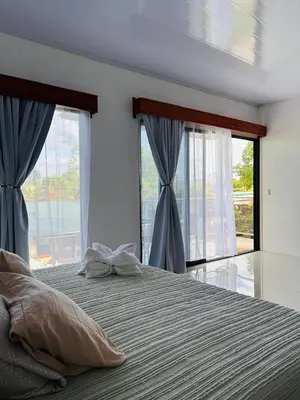 a bedroom with a large bed with two windows at Bella's Country Room in Tanque
