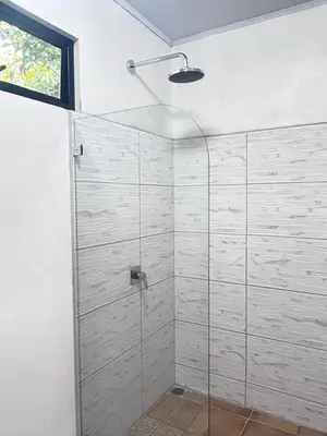 a shower with a glass door in a bathroom at Bella's Country Room in Tanque