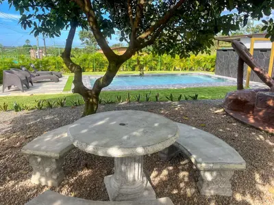 a stone bench sitting in front of a swimming pool at Casa La Finca Private Pool / AC WiFi 300Mbps in Fortuna