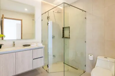 a bathroom with a glass shower and a toilet at Brand New Ocean View Condo overlooking Tamarindo in Tamarindo