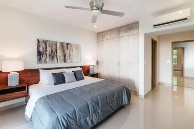 a bedroom with a bed and a ceiling fan at Brand New Ocean View Condo overlooking Tamarindo in Tamarindo