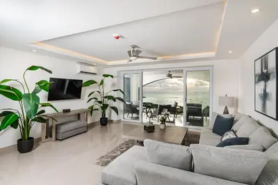 a living room with a couch and a tv at Brand New Ocean View Condo overlooking Tamarindo in Tamarindo
