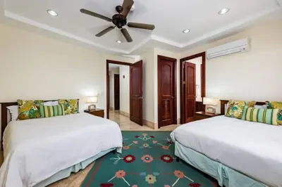 a bedroom with two beds and a ceiling fan at Beachfront, Sunset, & Ocean Views with Gas Grill in Tamarindo