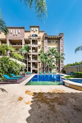 a building with a swimming pool in front of a building at Beachfront, Sunset, & Ocean Views with Gas Grill in Tamarindo