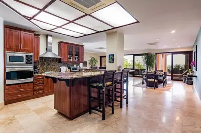 a large kitchen with a large island with bar stools at Beachfront, Sunset, & Ocean Views with Gas Grill in Tamarindo