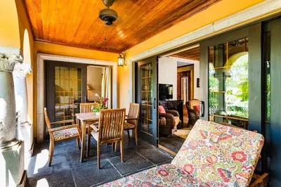 a screened in porch with a table and chairs at Sunset view roof terrace, steps to the beach! in Tamarindo