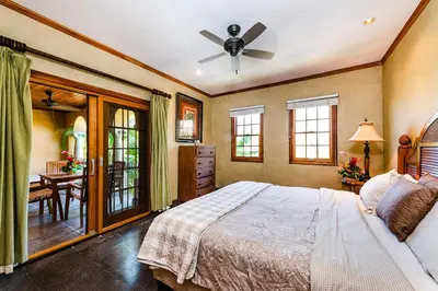 a bedroom with a bed and a ceiling fan at Sunset view roof terrace, steps to the beach! in Tamarindo