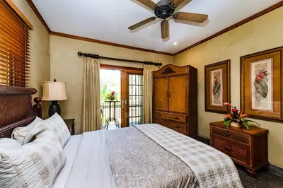 a bedroom with a bed and a ceiling fan at Sunset view roof terrace, steps to the beach! in Tamarindo
