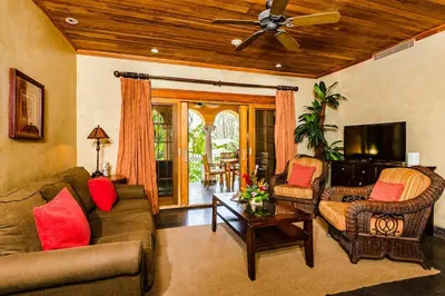 a living room with a couch and chairs and a ceiling fan at Sunset view roof terrace, steps to the beach! in Tamarindo