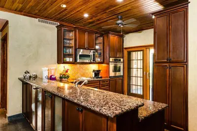 a kitchen with wooden cabinets and a granite counter top at Sunset view roof terrace, steps to the beach! in Tamarindo