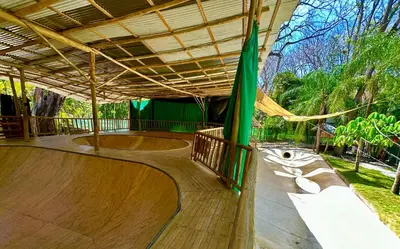 a skate park with a wooden skateboard ramp with a roof at Pacifica Surf Studios in Santa Teresa Beach
