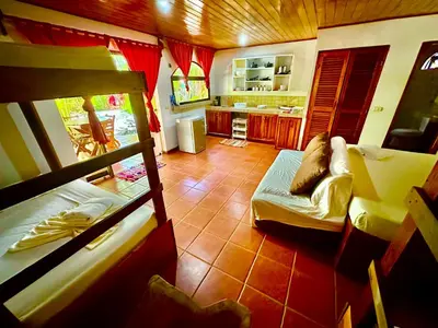 a living room with two bunk beds and a kitchen at Pacifica Surf Studios in Santa Teresa Beach