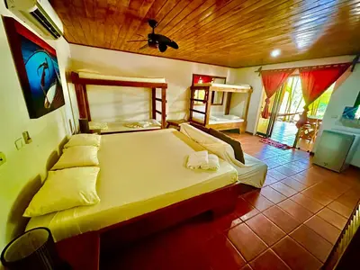 a bedroom with a large bed with a wooden ceiling at Pacifica Surf Studios in Santa Teresa Beach
