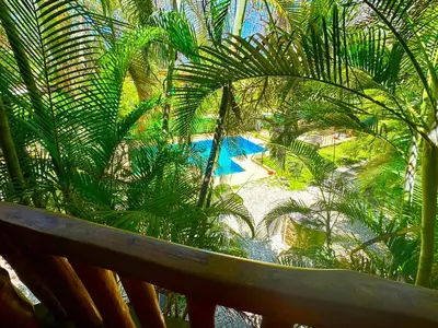 an overhead view of a resort with a pool and palm trees at Pacifica Surf Studios in Santa Teresa Beach