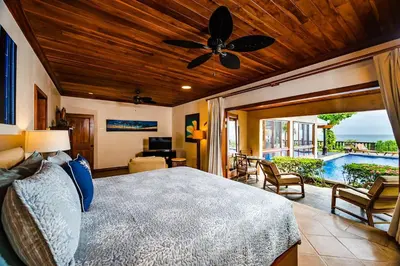 a bedroom with a bed and a patio with a pool at Exclusive Beachfront Villa Private Pool, Koi, BBQ in Tamarindo