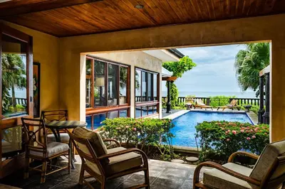 a patio with a table and chairs and a swimming pool at Exclusive Beachfront Villa Private Pool, Koi, BBQ in Tamarindo