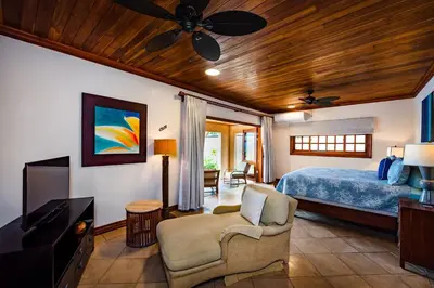 a bedroom with a bed and a flat screen tv at Exclusive Beachfront Villa Private Pool, Koi, BBQ in Tamarindo