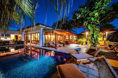 an exterior view of a house with a swimming pool at Exclusive Beachfront Villa Private Pool, Koi, BBQ in Tamarindo