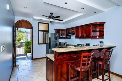 a kitchen with a center island with bar stools at Pool & AC Close to Beach with free bikes! in Tamarindo