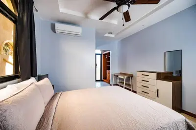 a bedroom with a bed and a ceiling fan at Pool & AC Close to Beach with free bikes! in Tamarindo