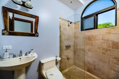 a bathroom with a toilet and a sink and a shower at Pool & AC Close to Beach with free bikes! in Tamarindo