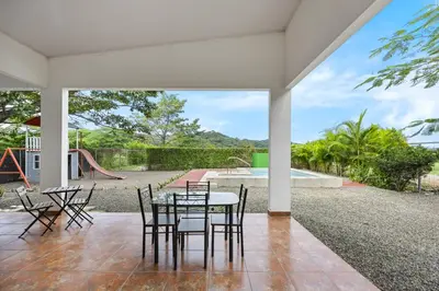 a patio with a table and chairs and a playground at Casa Las Mariposas Fantastic Home With Nature Views & Private Pool in Jobos