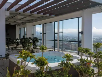 a hot tub in the middle of a building with windows at Urban Executive Stay in San José