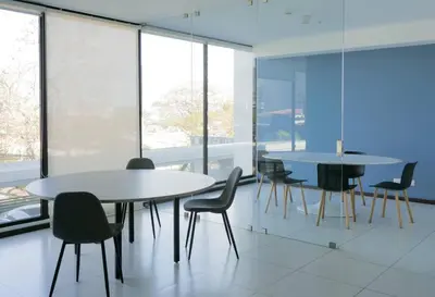 two tables and chairs in a room with windows at Urban Executive Stay in San José