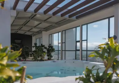 a large swimming pool in a building with windows at Urban Executive Stay in San José