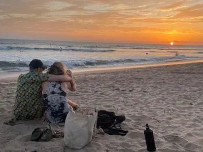 a couple sitting on the beach watching the sunset at Spacious & serene with partial ocean & jungle view in Tamarindo