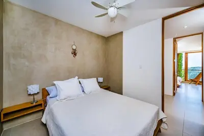 a bedroom with a bed and a ceiling fan at Spacious & serene with partial ocean & jungle view in Tamarindo