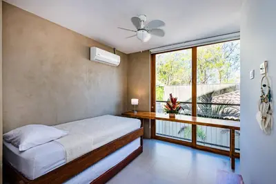 a bedroom with a bed and a large window at Spacious & serene with partial ocean & jungle view in Tamarindo