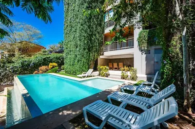 a swimming pool with two lounge chairs next to a building at Spacious & serene with partial ocean & jungle view in Tamarindo