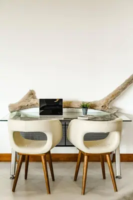 a glass table with two white chairs in a room at Amazing New Peninsula Penthouse with Ocean Views in Tamarindo